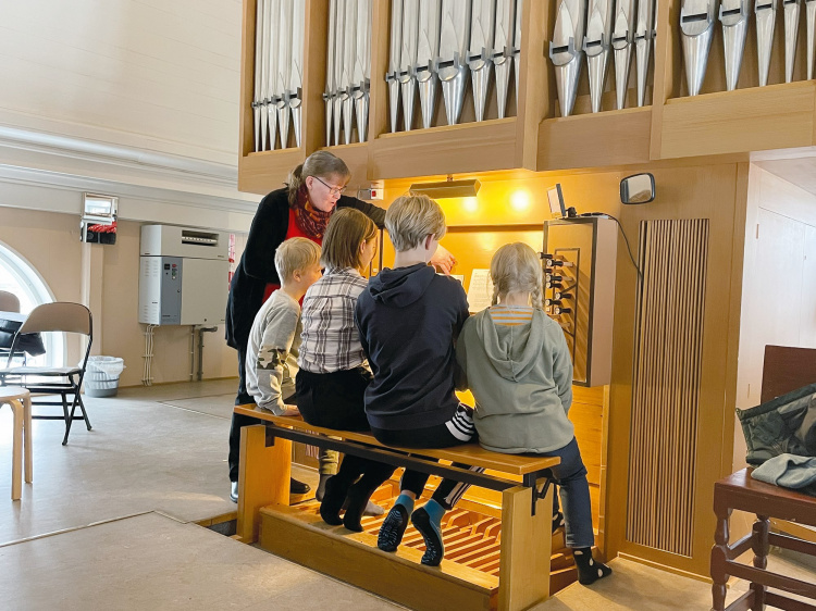 Kvinna och barn spelar på en orgel.