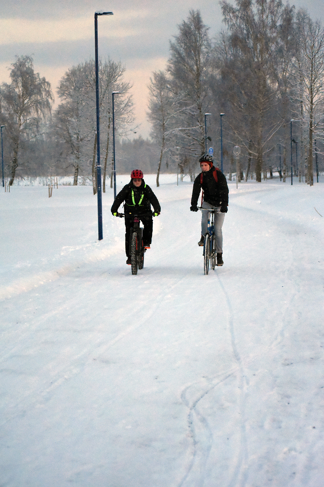 En kvinna och en man cyklar en vinterdag.