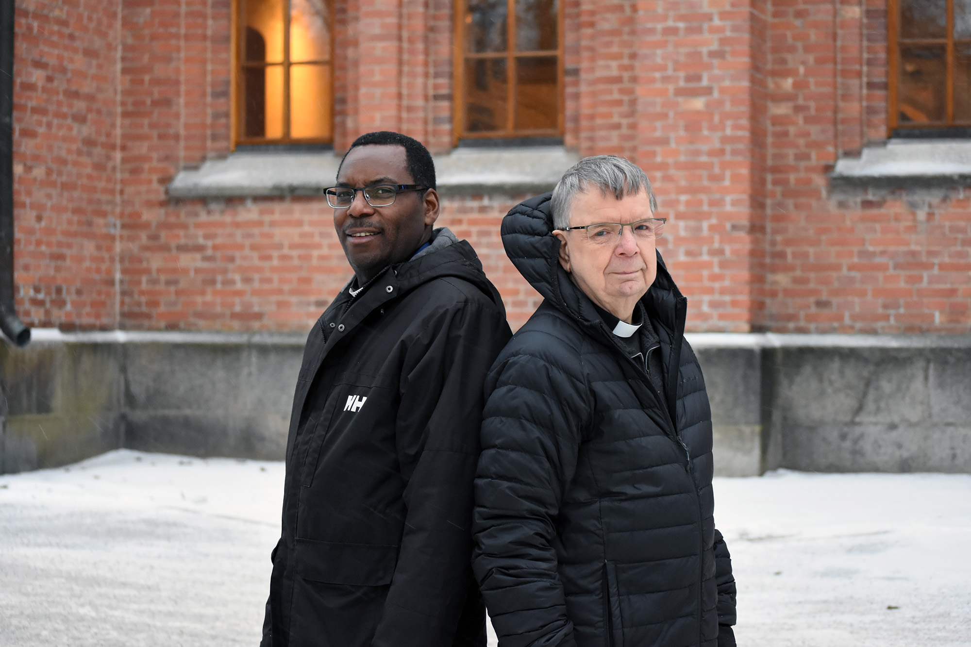 Två män utanför en kyrka en kall vinterdag.