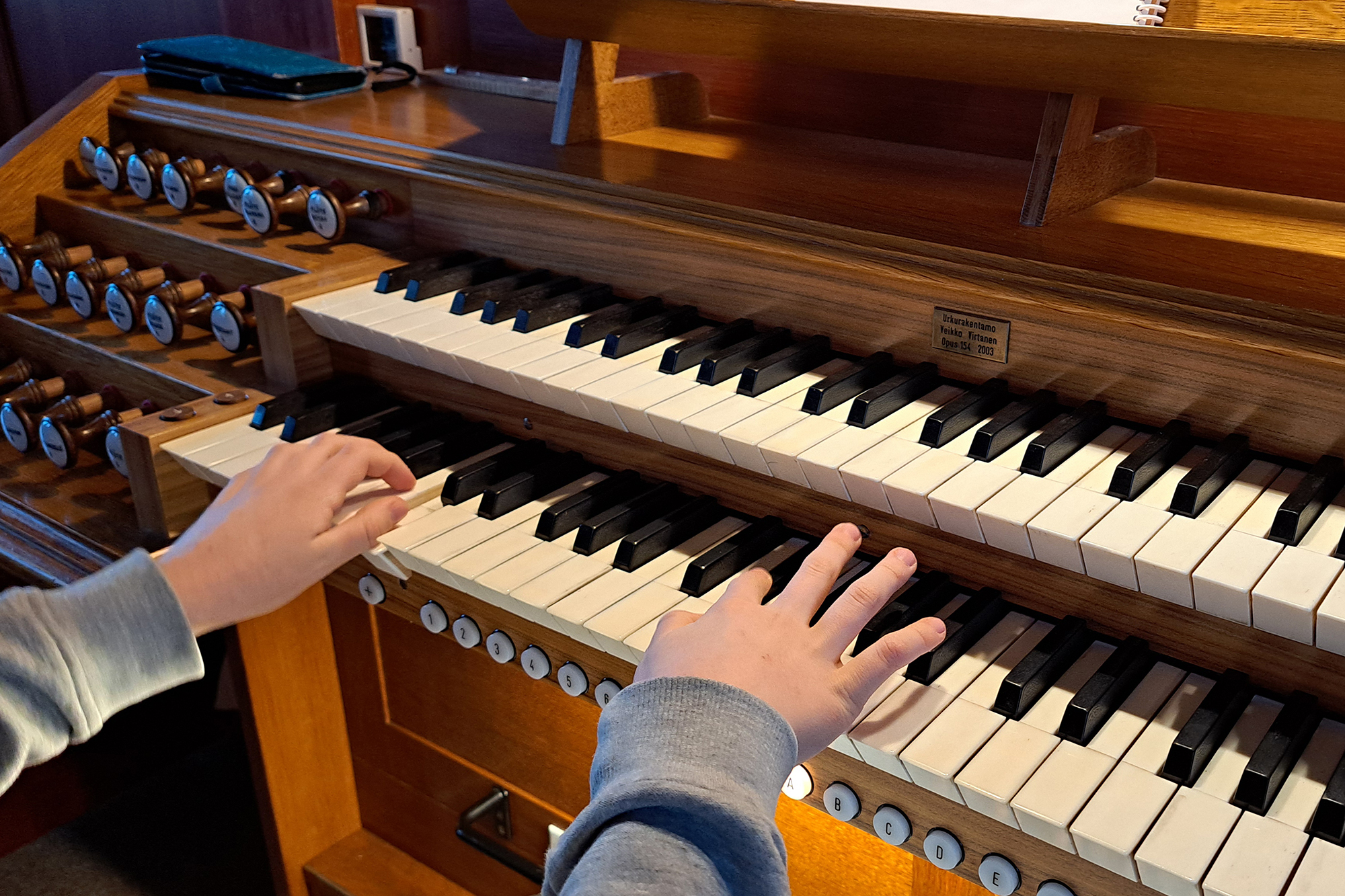 Barnhänder på en orgels tangeter.