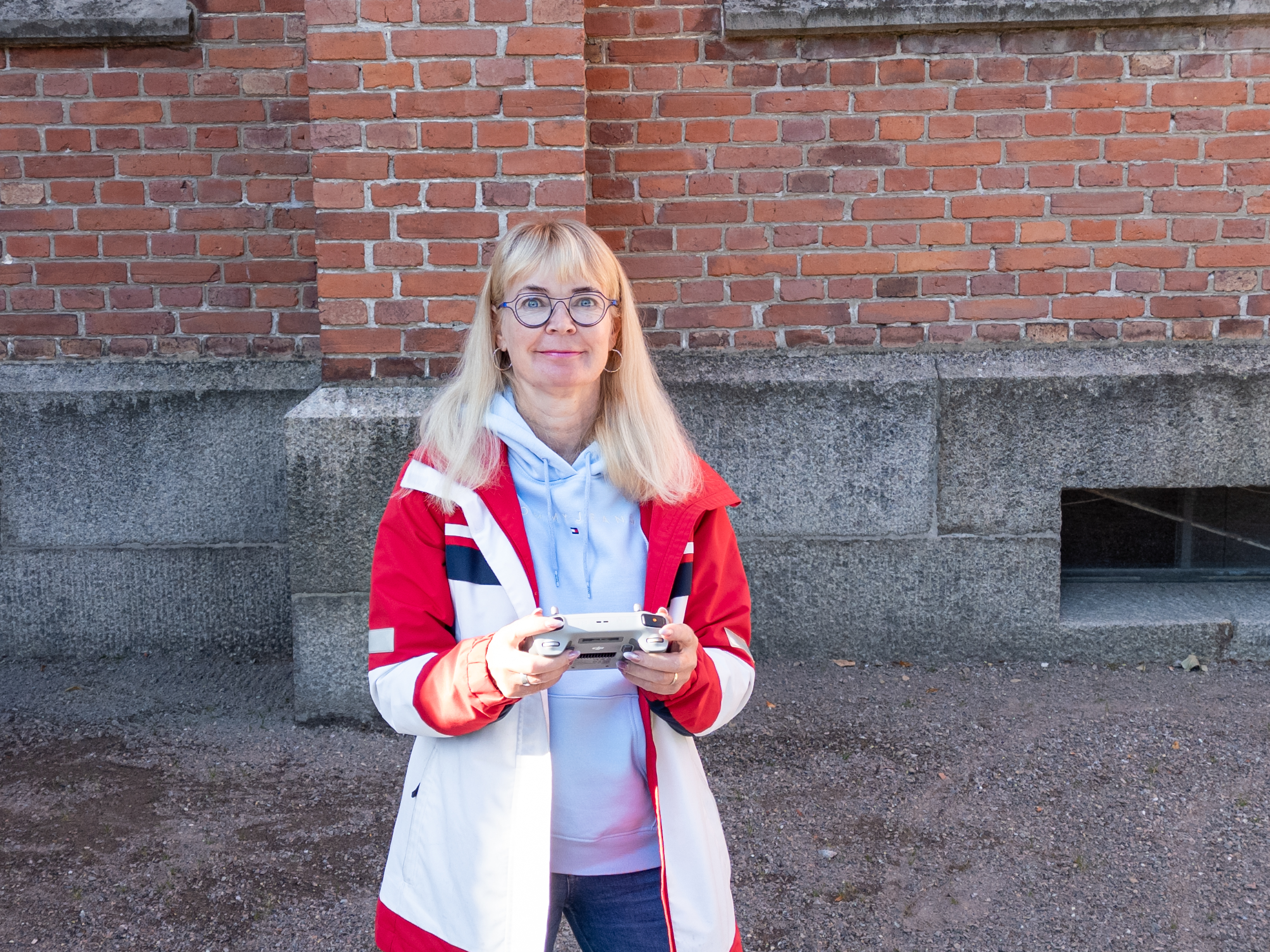 Kvinna med en drönarkontroll i handen.