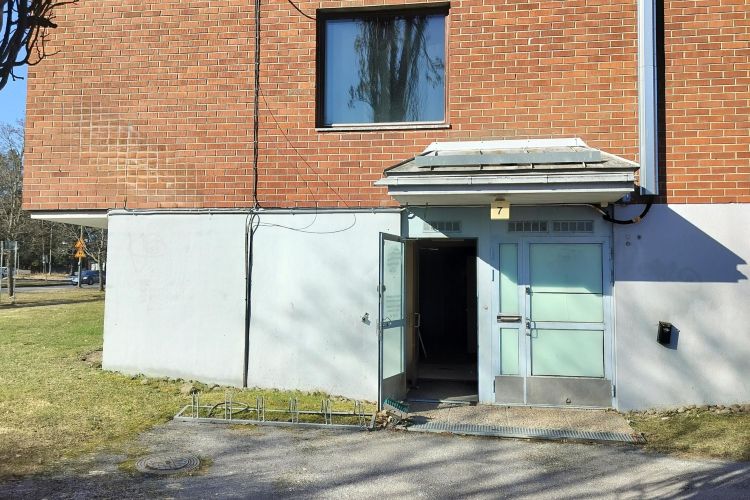 Gaveln av ett rött tegelhus. Öppen dörr.