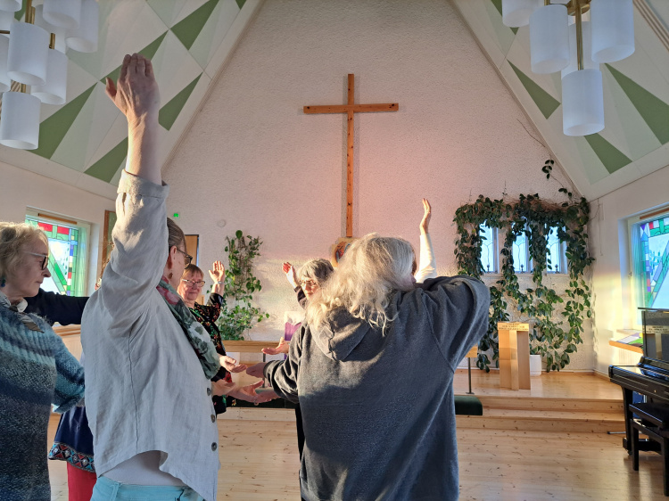 Människor i rörelse i en kyrksal.