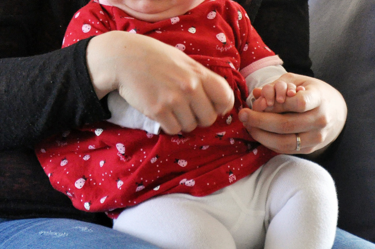 Babyhänder i en vuxens händer.