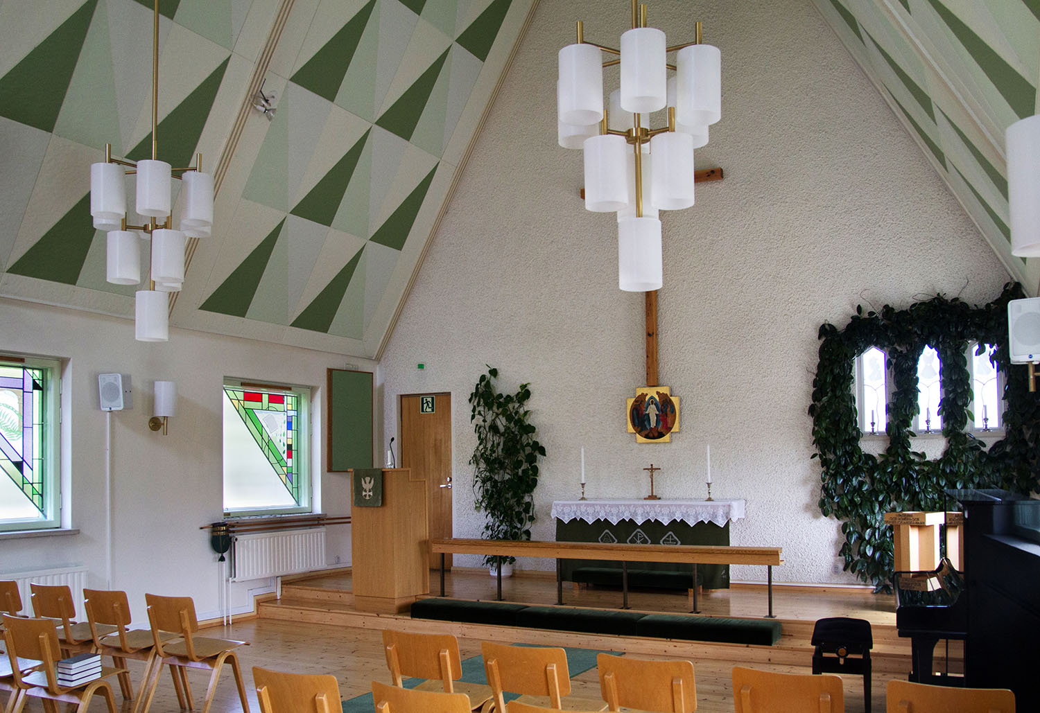 Strömmad gudstjänst Mysig kyrksal med tak i grönt och vitt.