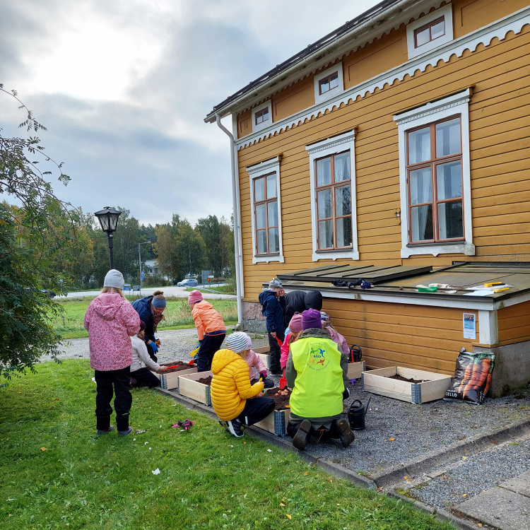 Barn som planterar något på en gård.