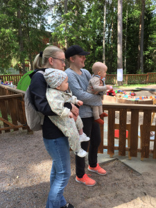 Två kvinnor står och tittar med sina babysar 