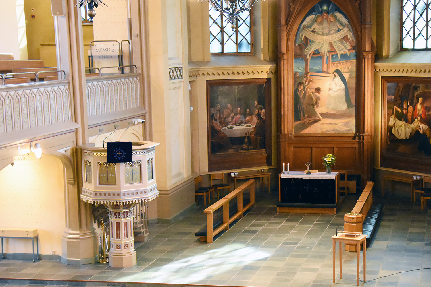 Stilla dig i kyrkan Trefaldighetskyrkans altare med tre altartavlor. Altarduken har den vita liturgiska färgen.