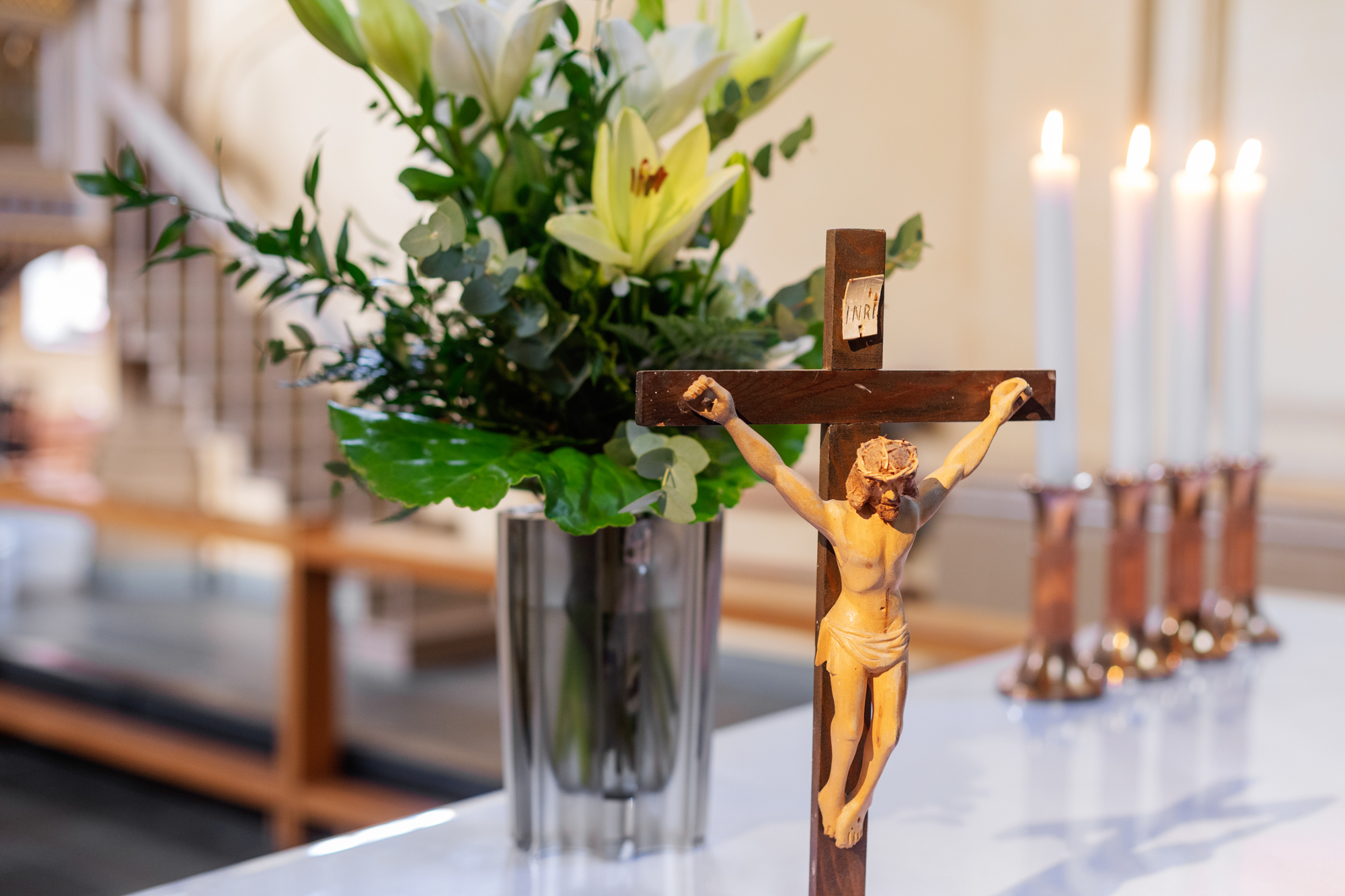 Altare med krucifix och vita liljor.