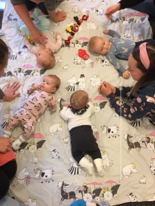 Babysar leker på filt. 