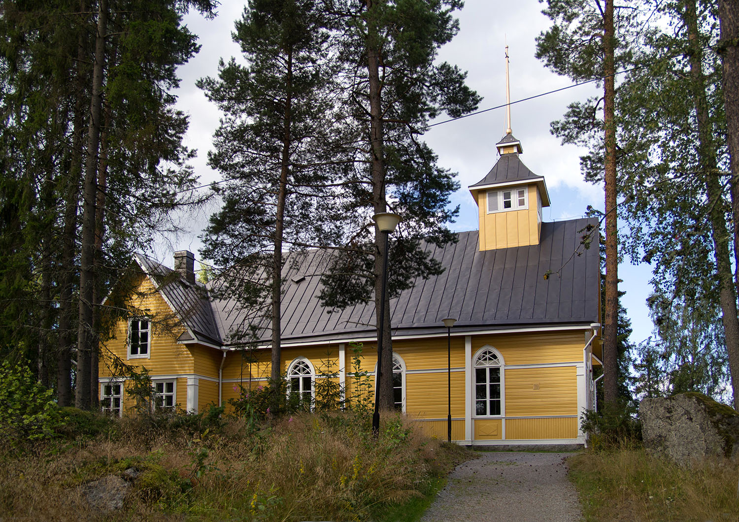 Gudstjänst från Sundom kyrka Gul i kyrka i en skogsbacke.