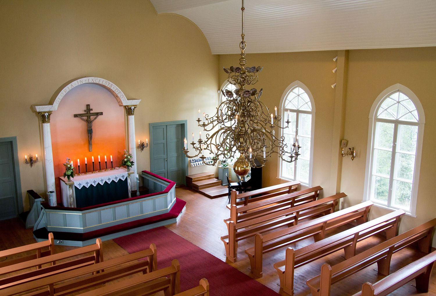 Skärtorsdagsgudstjänst på Youtube och i Sundom tv Altaret i Sundom kyrka uppifrån sett. I taket hänger en vacker ljuskrona.