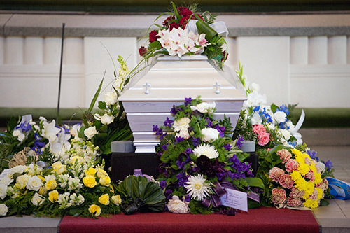 Blomsterprydd kista. Länken leder till webbsidan om begravning.