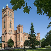 Trefaldighetskyrkan Röd tegelkyrka i nygotisk stil med högt torn med fyra kyrkspiror vid huvudingången. Ljusgrönt plåttak.