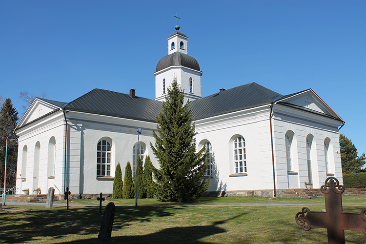 Vit stenkyrka med mörkgrått plåttak