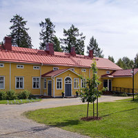 Haga prästgård Gårdsplan med gul träbyggnad med rött plåttak.