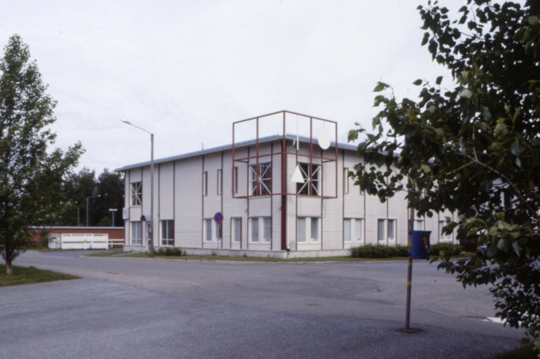 Sunnanvik församlingshem Vit tvåvåningsbyggnad med röda metallkonstruktioner i ena övre hörnet.