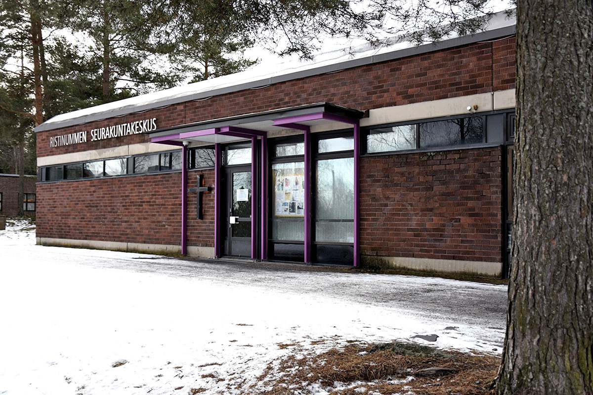 Mörkbrun tegelbyggnad tagen på vintern när det är lite snö på marken.