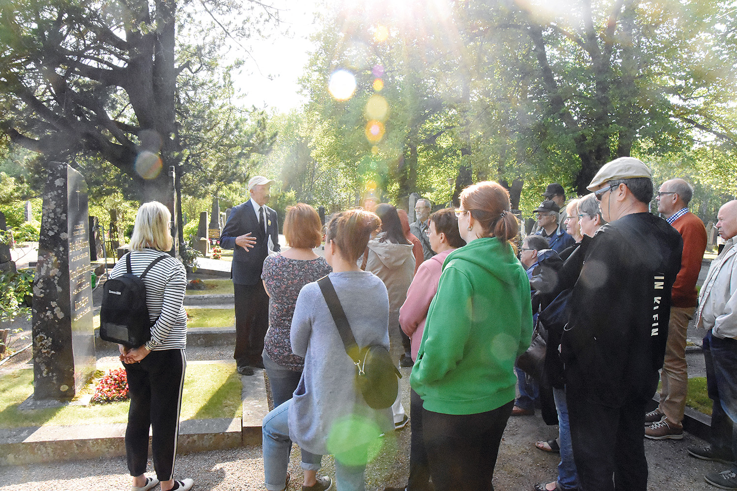 En folksamling på gravgården lyssnar på guiden Henrik Fågelbärj.