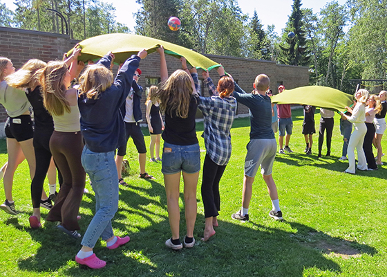 Ungdomar kastar bollar i luften med hjälp av filtar.