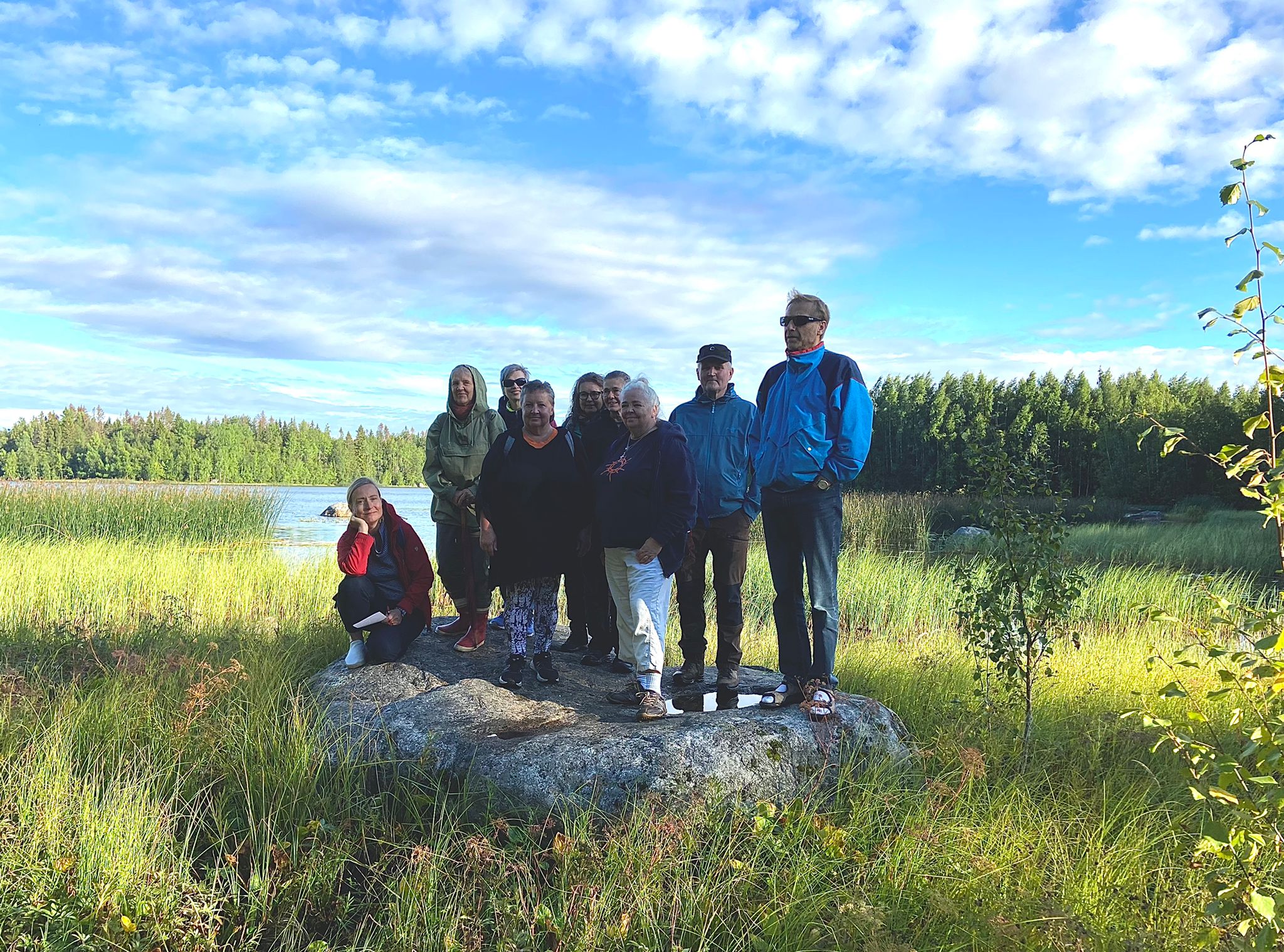 En grupp människor står på en sten i naturen.