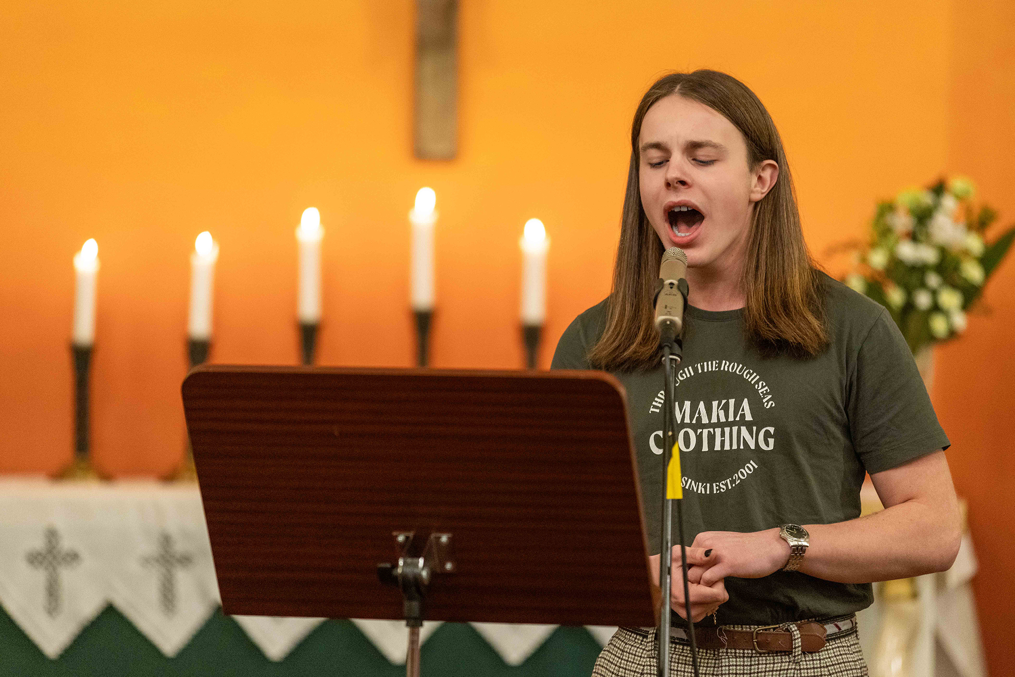 Ung man som sjunger i en kyrka.
