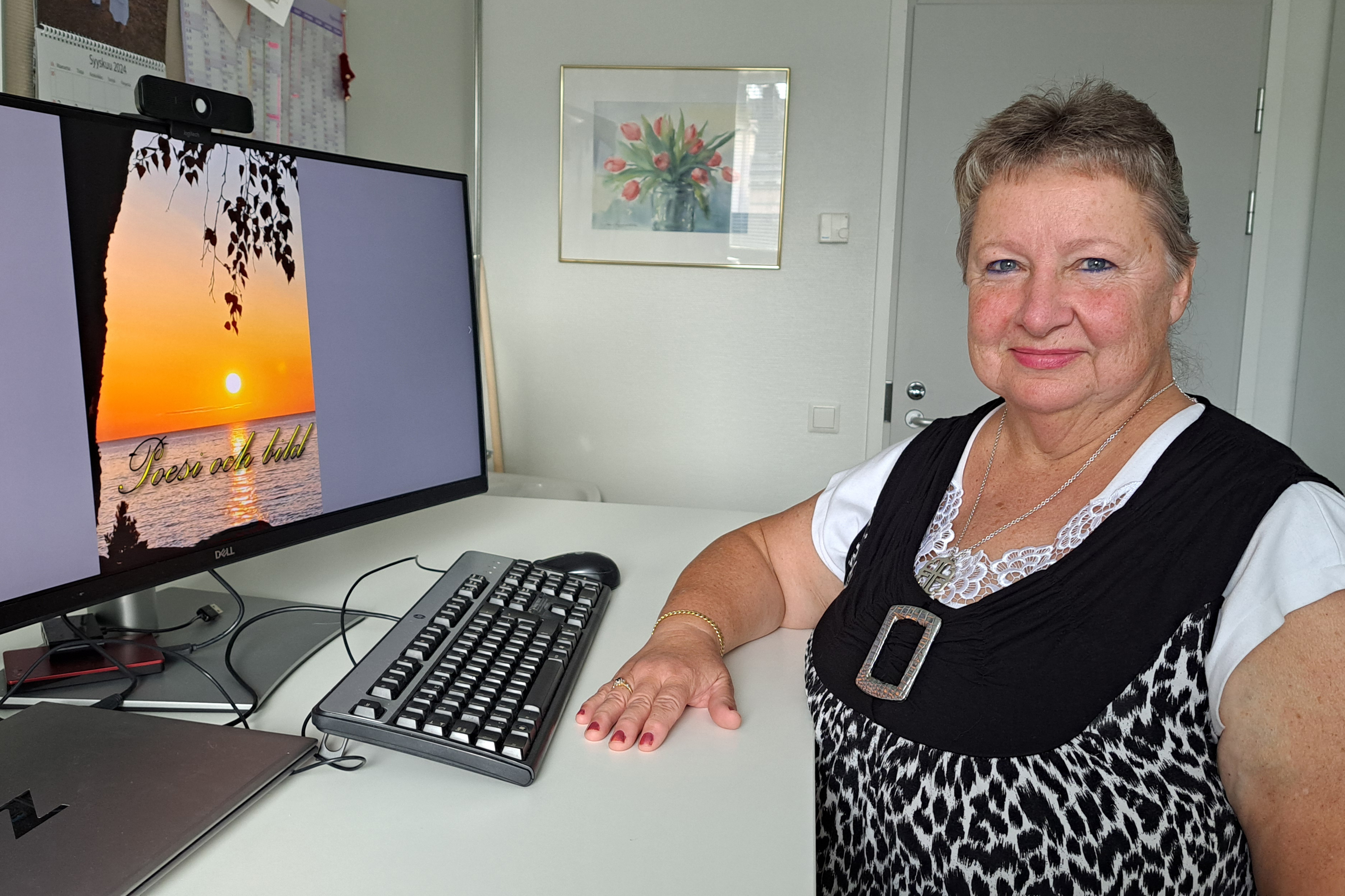 Kvinna står framför en datorskärm.
