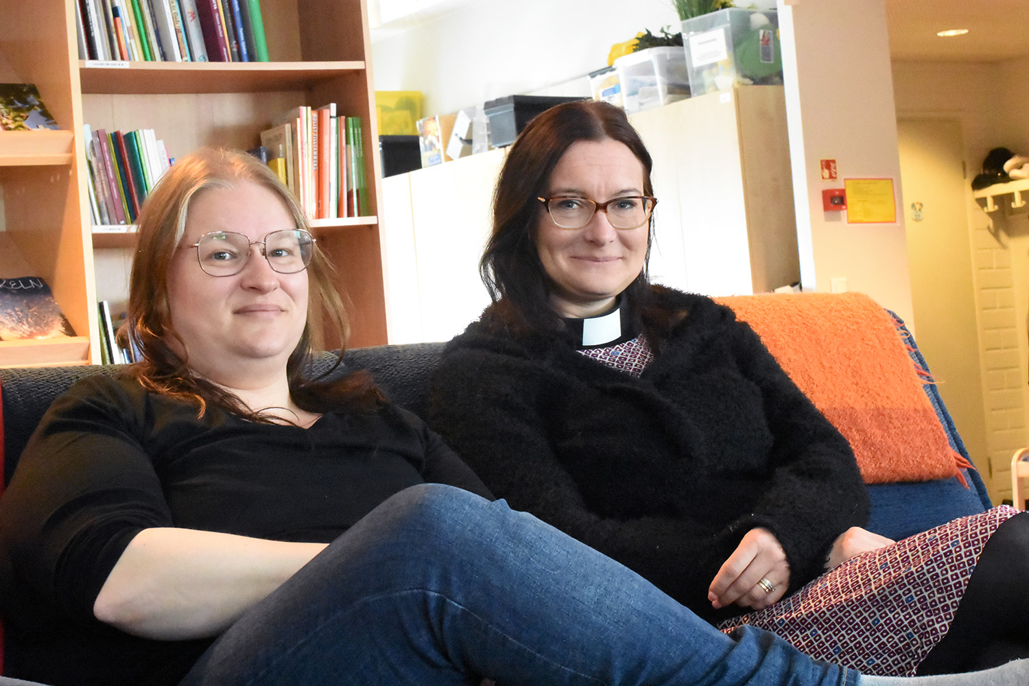 Två kvinnor sitter i en soffa.