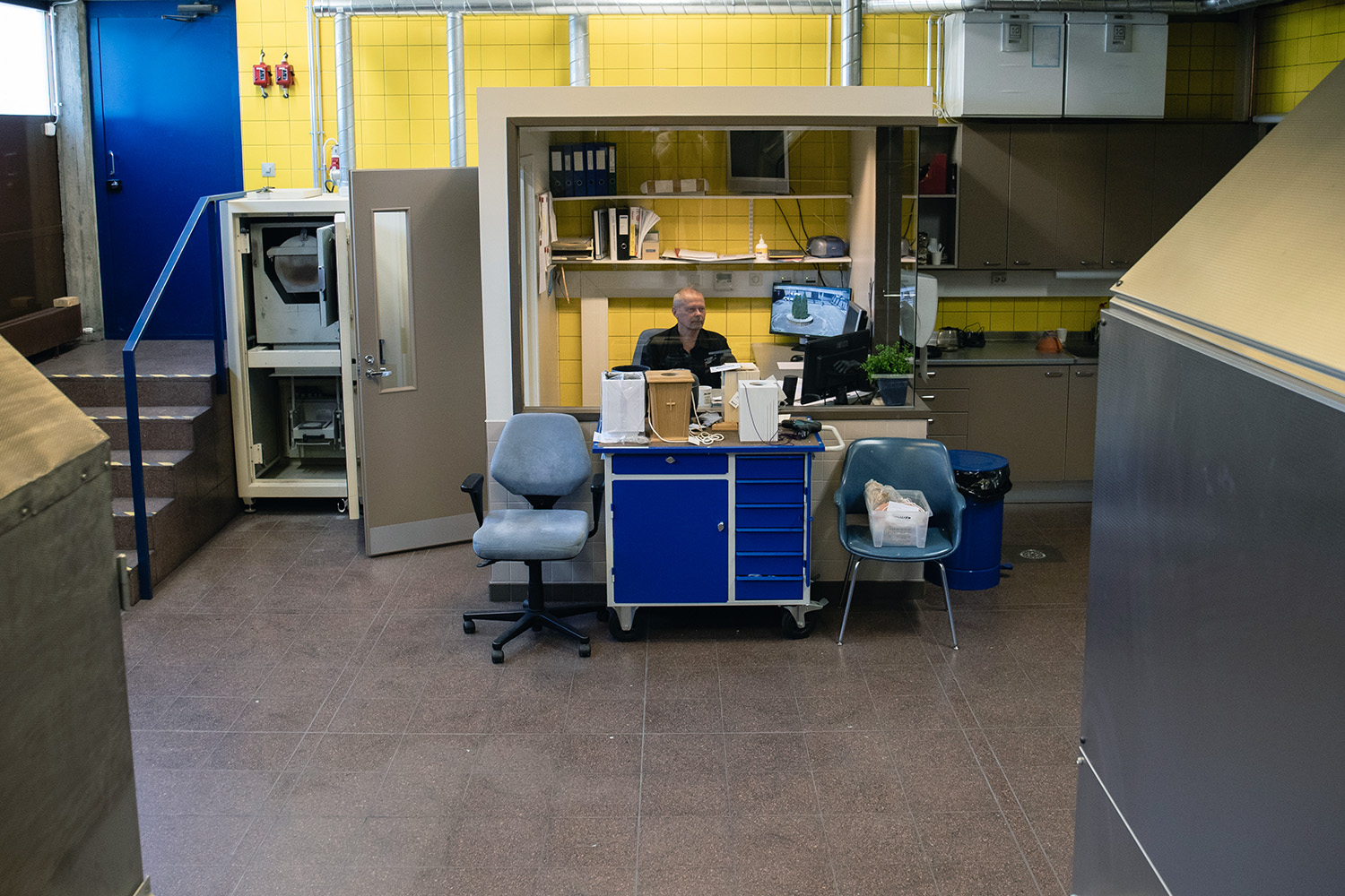 Vesa Korpi sitter vid ett arbetsbord i ett rum med gula kakel.