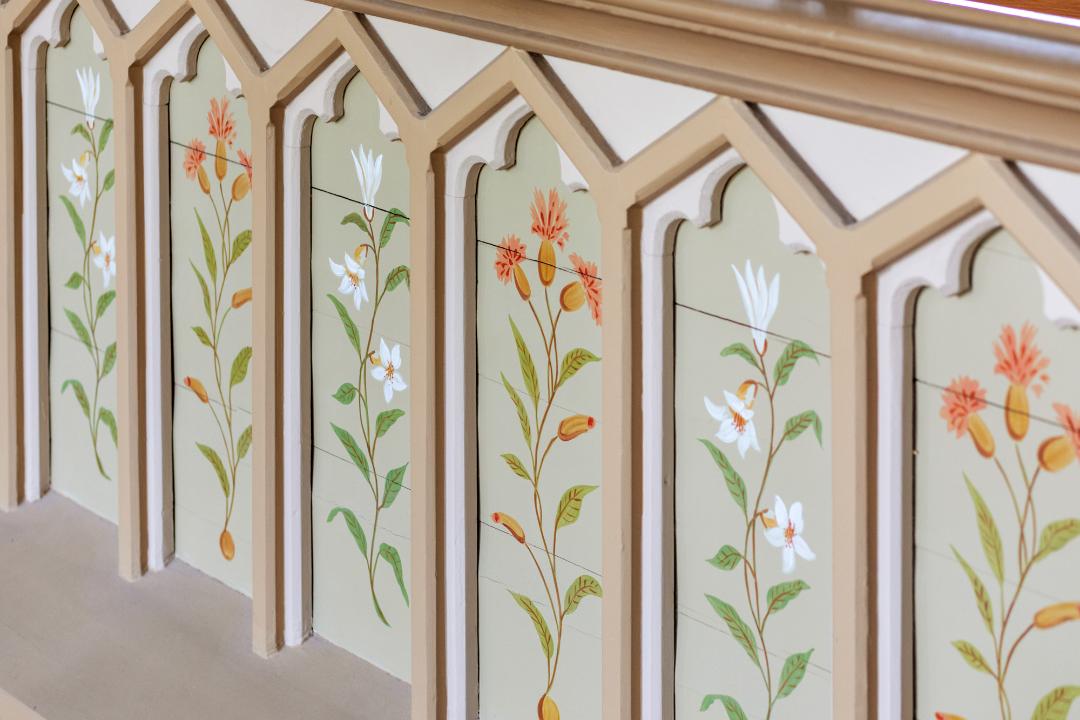 Träräcke målat med vita och röda blommor.