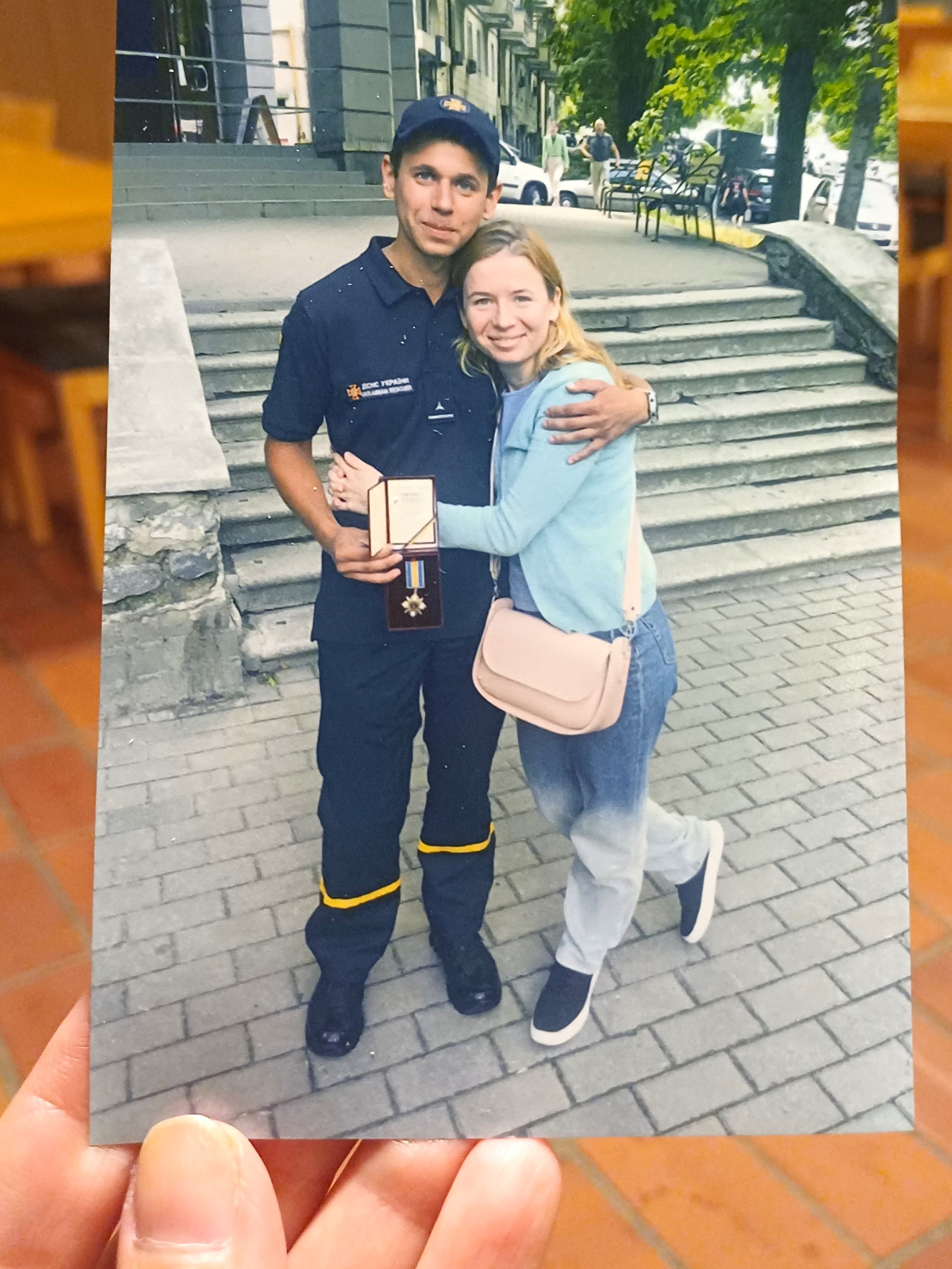 hand håller i ett foto som föreställer en man och en kvinna.