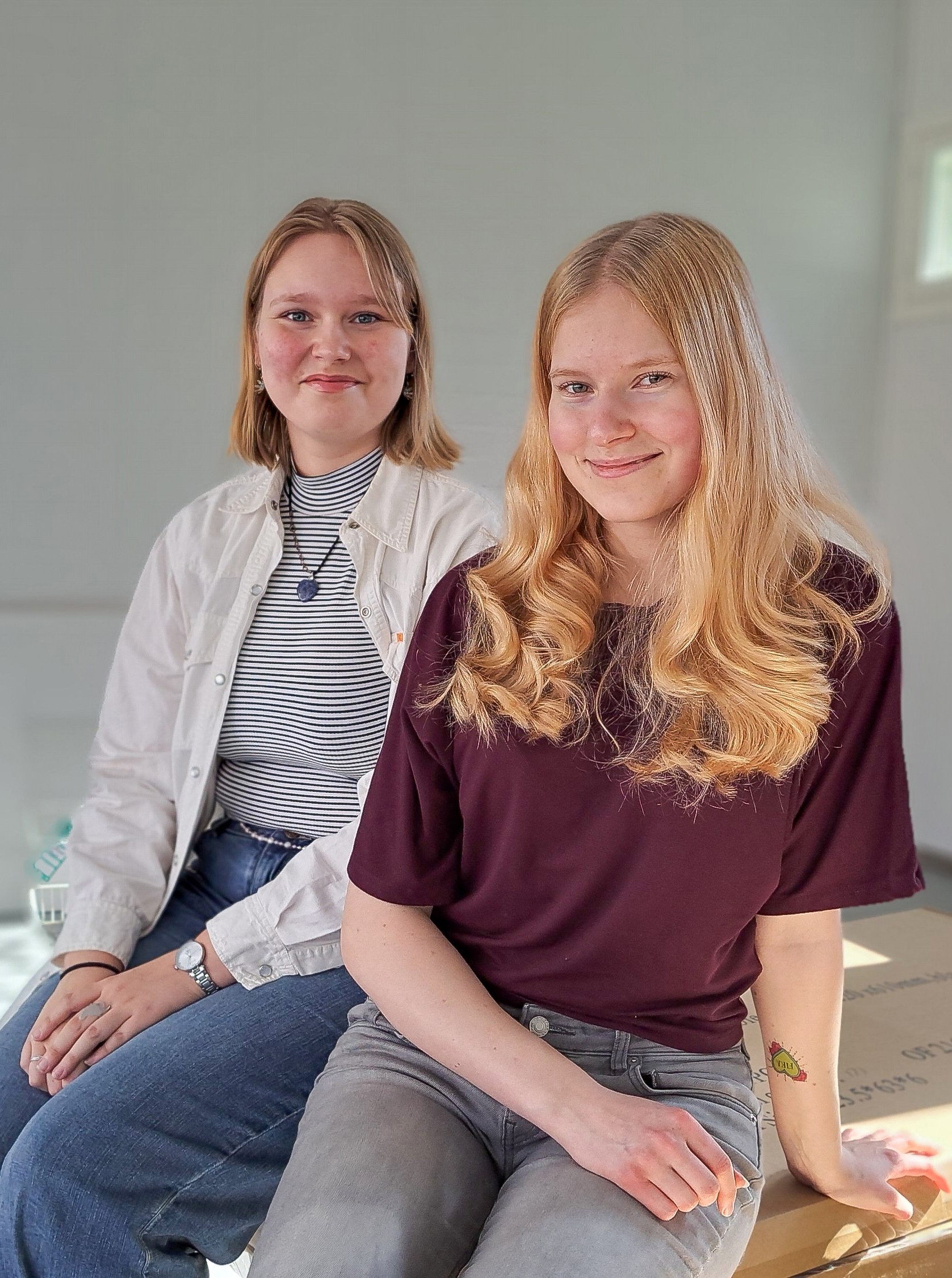 Två unga kvinnor sitter i en lokal som renoveras.