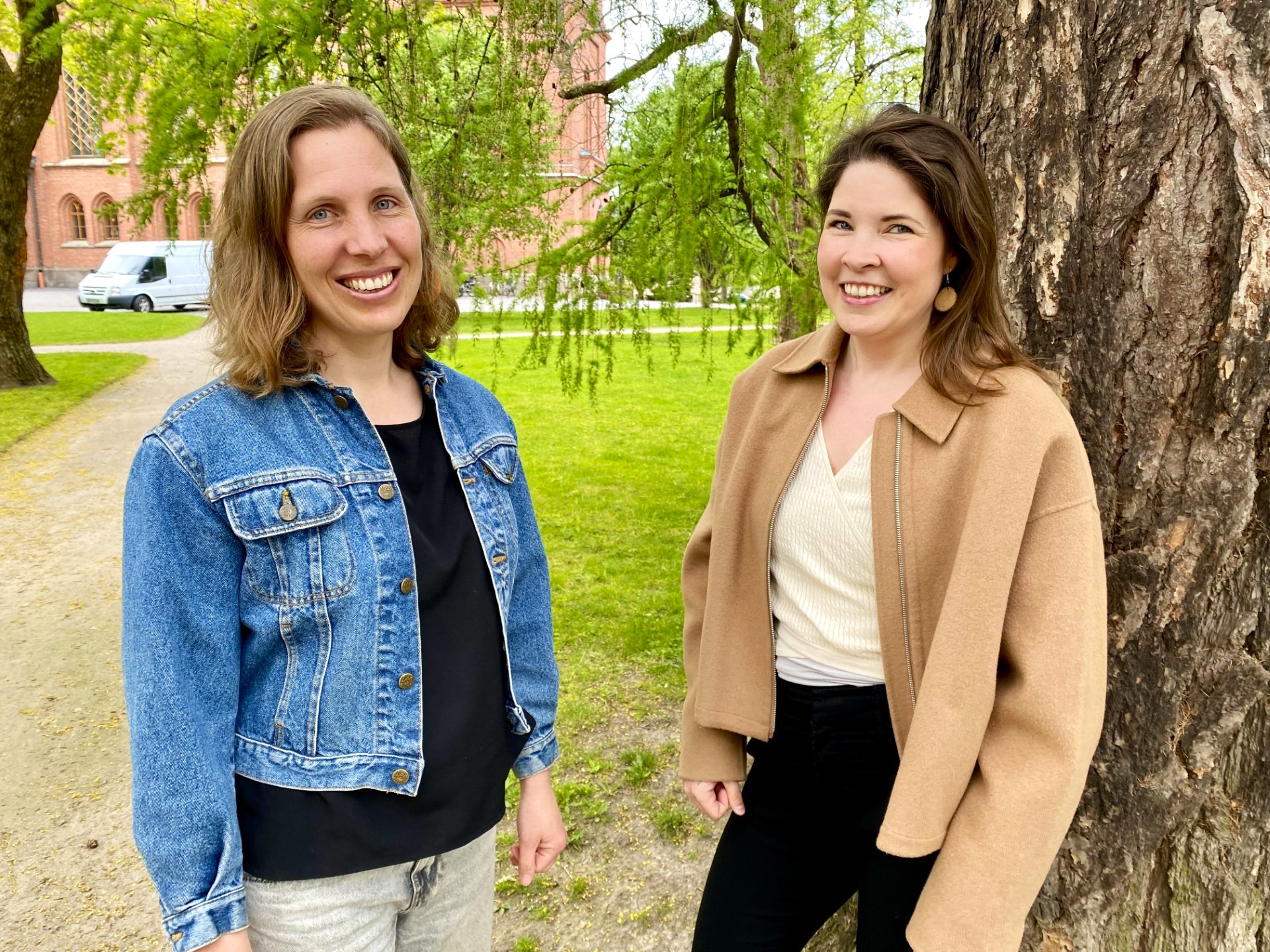 Två glada kvinnor i en park.