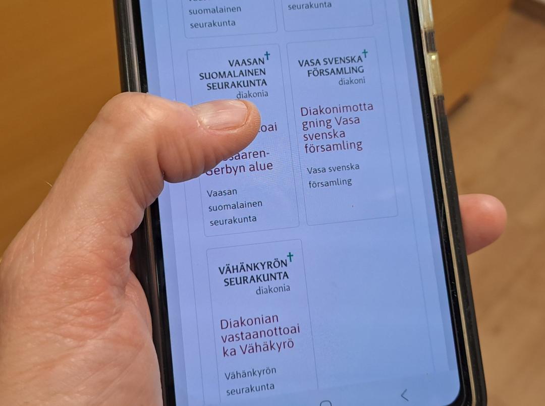 Hand håller i en mobiltelefon.