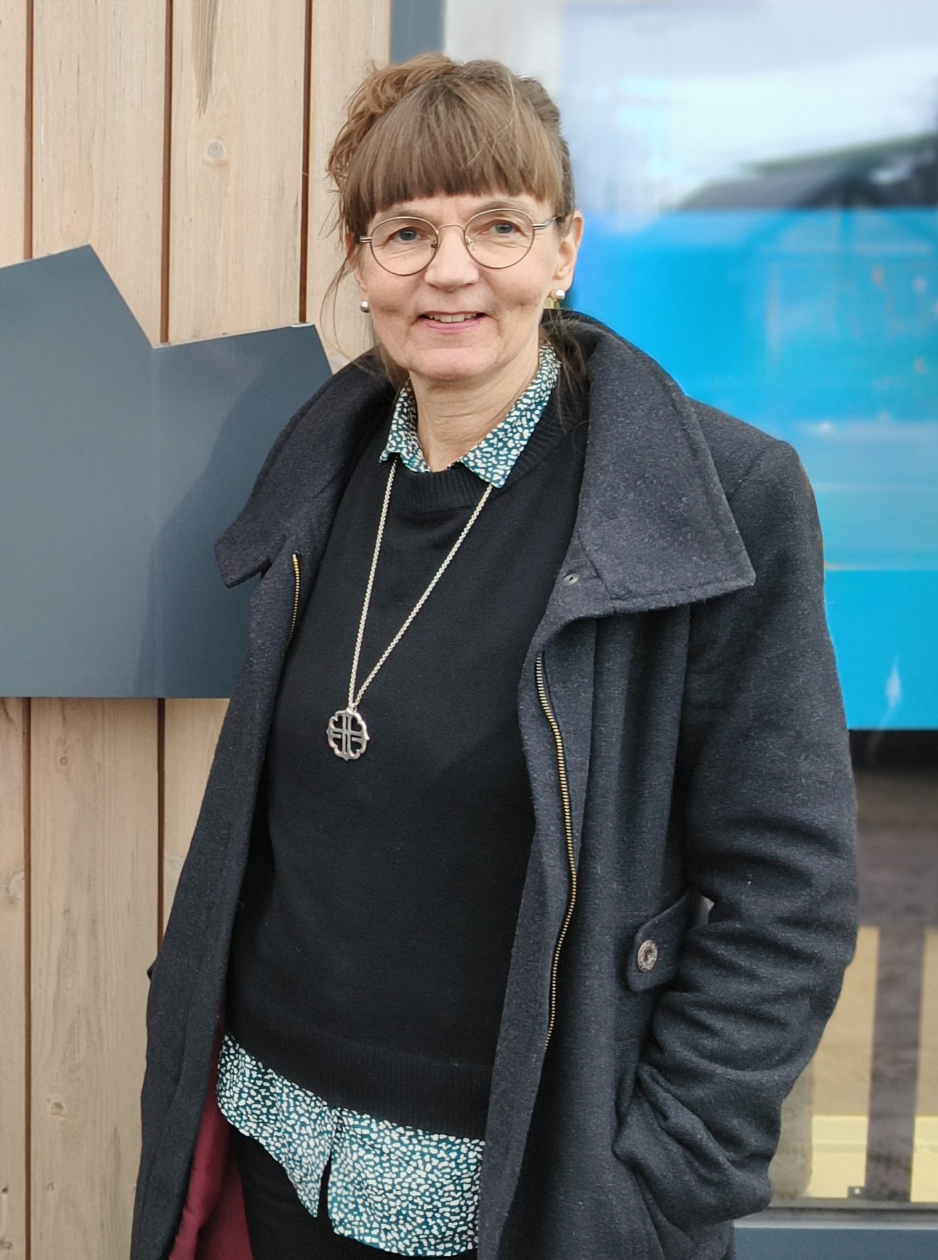 Kvinna som står framför en byggnad.