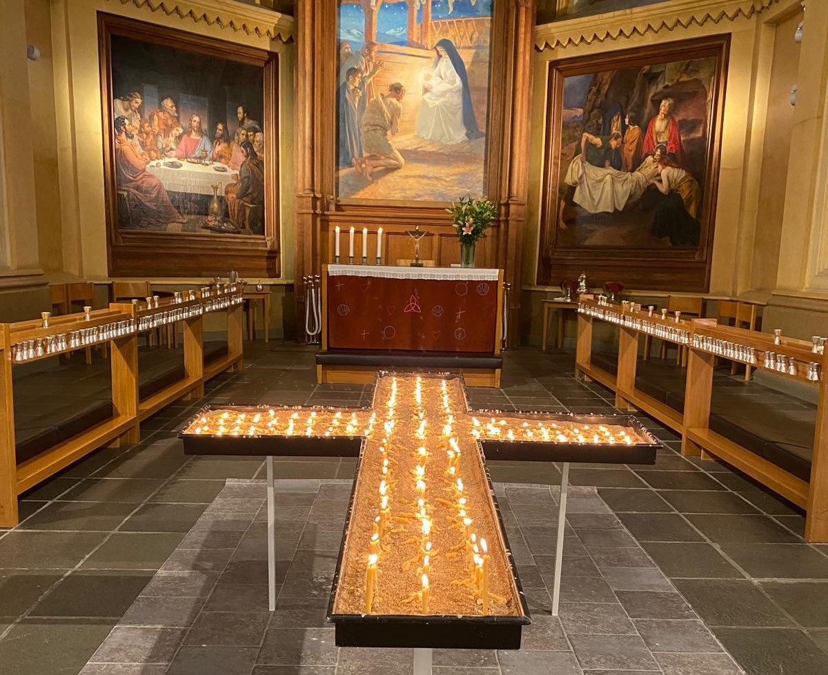 Kors av brinnande ljus i en kyrka.