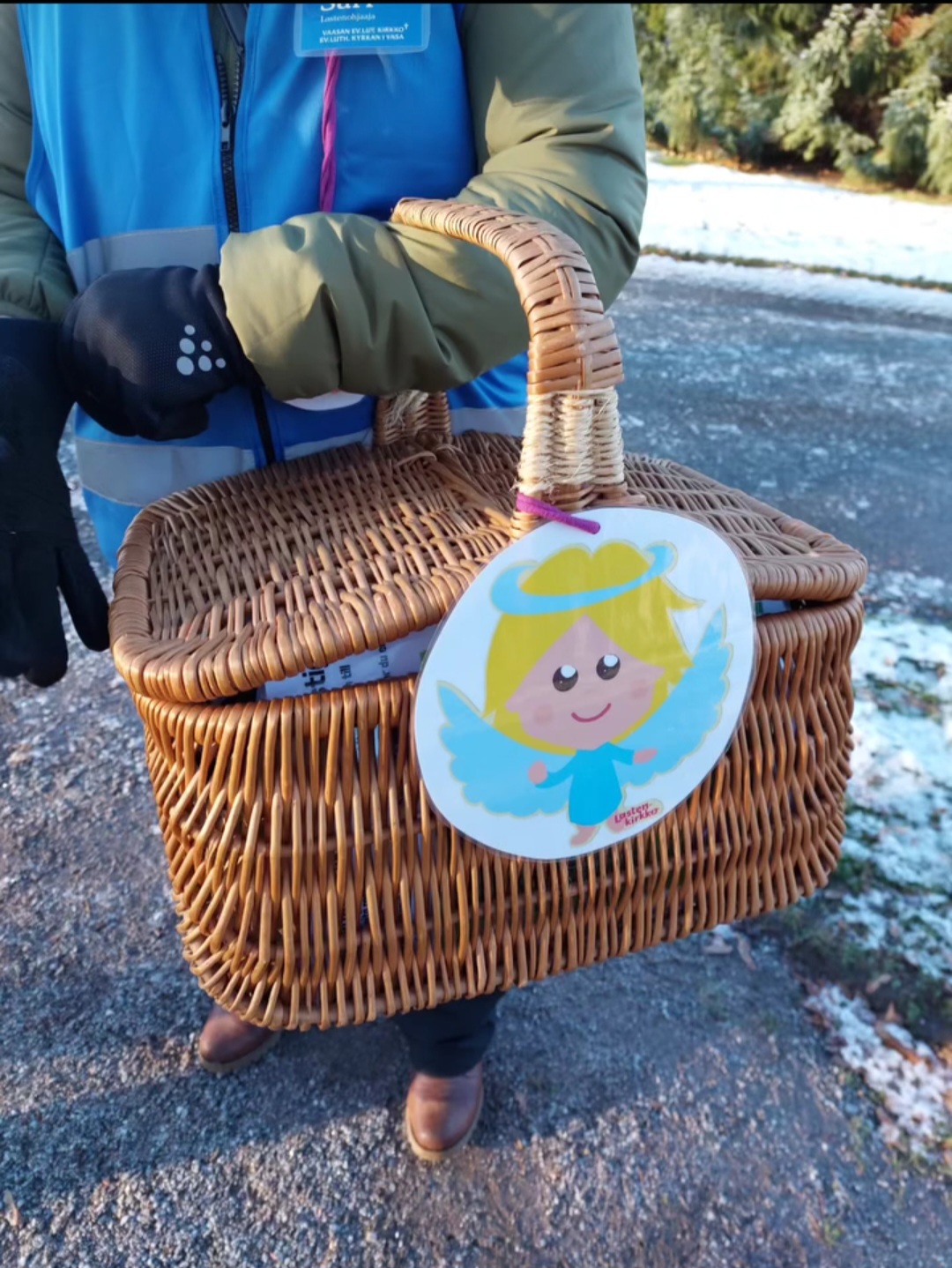 Någon håller i en korg med en ängel på.