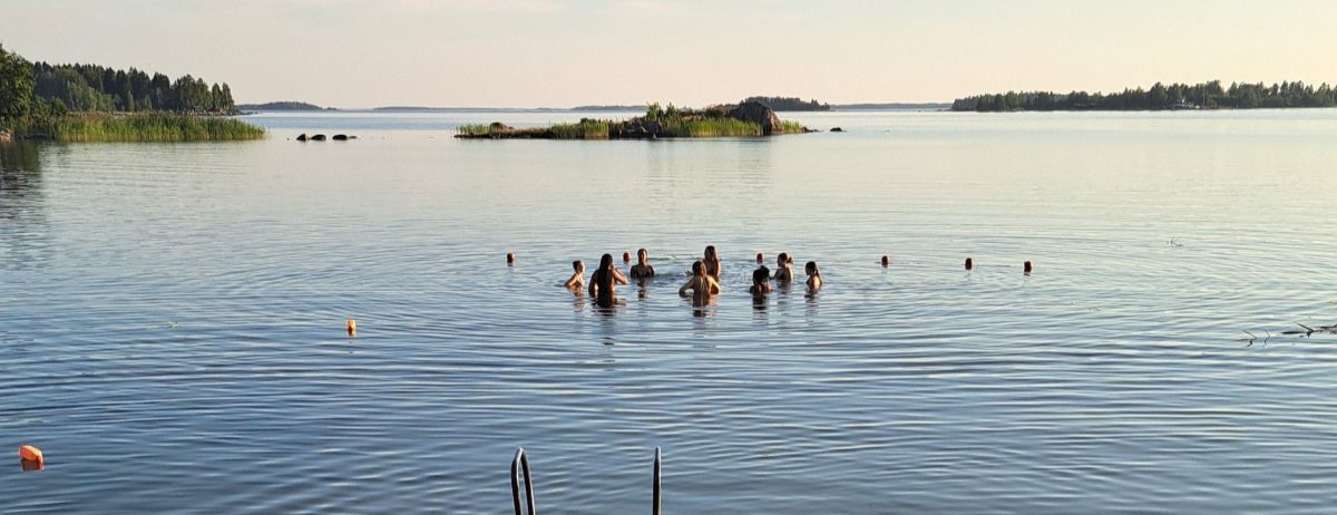Ungdomar simmar i havet.